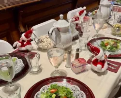 A close-up shot of an elegant place setting on a dining table, featuring a white plate.