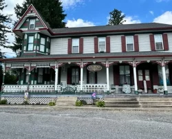 A beautiful old Victorian-style house with a large porch.