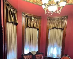 Victorian-style sitting room with red walls and vintage furniture.