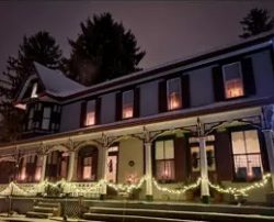 Bed-and-breakfast building with warm lights at night.